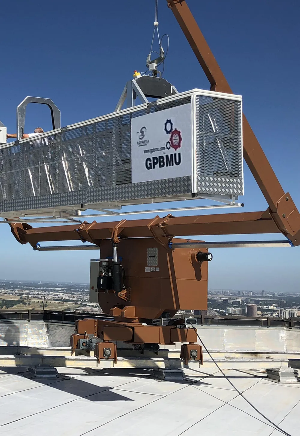 Rooftop GPBMU machine lifting its branded cradle against a clear sky