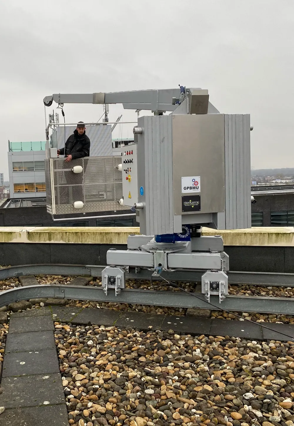 Operator in a GPBMU cradle on a roof rail above a European city