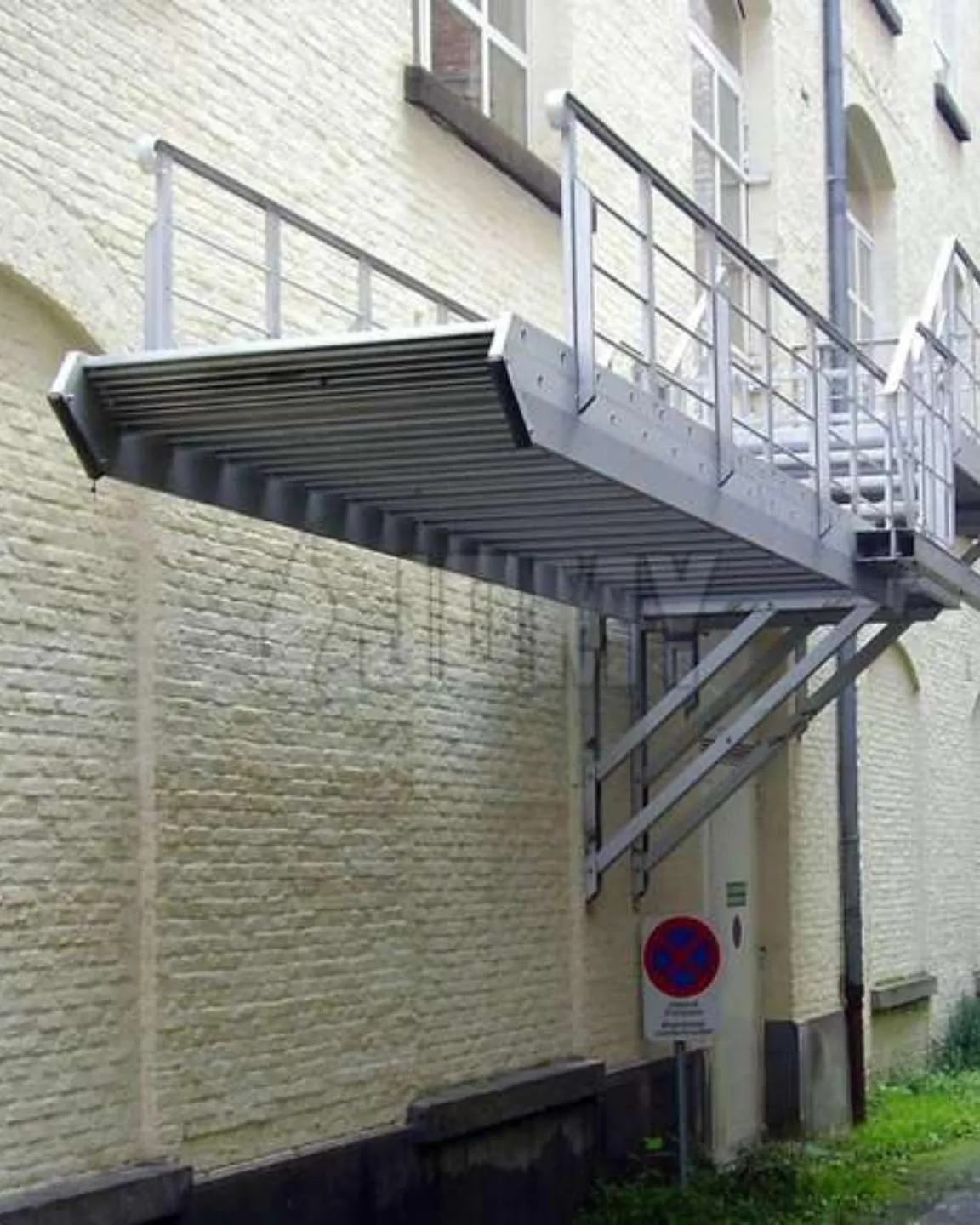Jomy retractable flight stairs on a brick facade