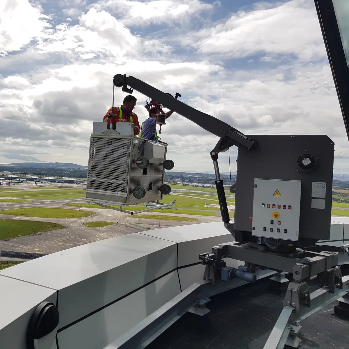 Two technicians in a GPBMU cradle at the control panel above Dublin Airport